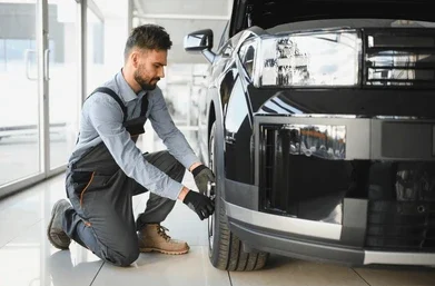 Mechanic Themed Tire Puns showing a friendly mechanic working beside a car and tire in a clean garage