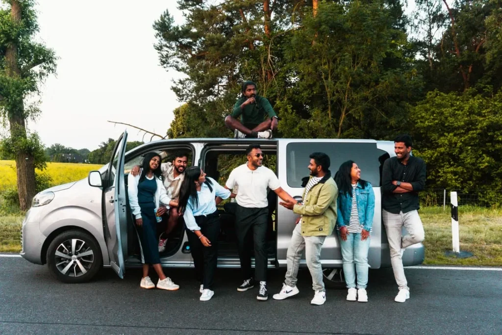 Tire Puns for Friends showing friends laughing beside a parked car during a fun road trip